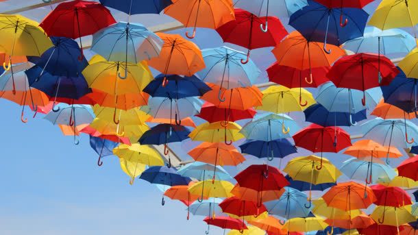天空上的彩色雨伞海报背景背景