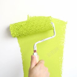 绿色手臂粉刷白墙的手高清图片