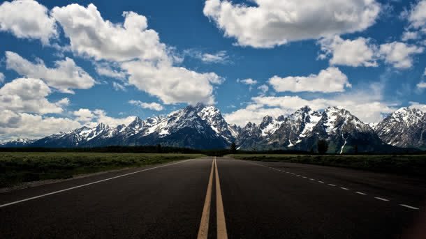 蓝天白云雪山下的高速公路背景