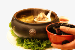 汽锅鸡手里端着一碗从砂锅里舀出来的鲜高清图片