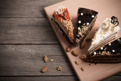 草莓蛋糕切块在木板上的巧克力蛋糕切块高清图片