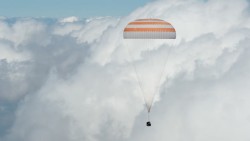 高空降落高空云层降落伞飘落高清图片