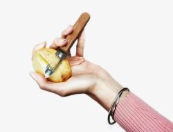 手拿遥控器的土豆创意手拿刨子削土豆高清图片