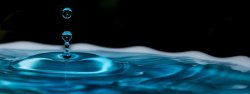 荡起04087蓝色的晶莹剔透的水滴连续滴落在水面上荡起高清图片