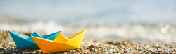 纸船摄影沙滩上的纸船背景高清图片
