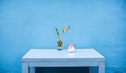 米洛蓝色墙面白色的桌子文艺放着玻璃瓶的桌子米洛milu高清图片