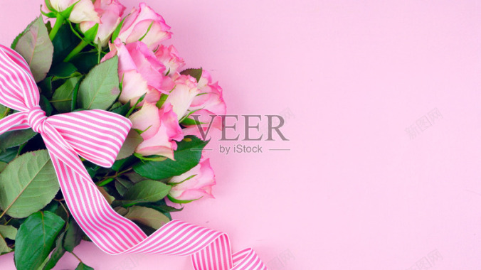 母亲节那天的粉红色玫瑰与粉红色的木桌上的副本空间花背景