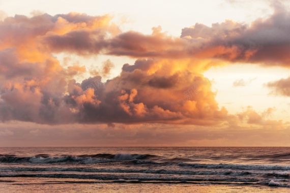 海浪上的蓬松日落云背景