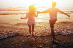 海滩情侣手牵手嬉戏的情侣人物高清图片