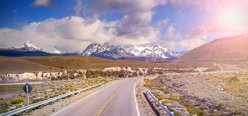 山间公路背景图jpg设计背景_新图网 https://ixintu.com 雪山 公路 杂草 云朵 摄影 粗矿 海报banner 风景