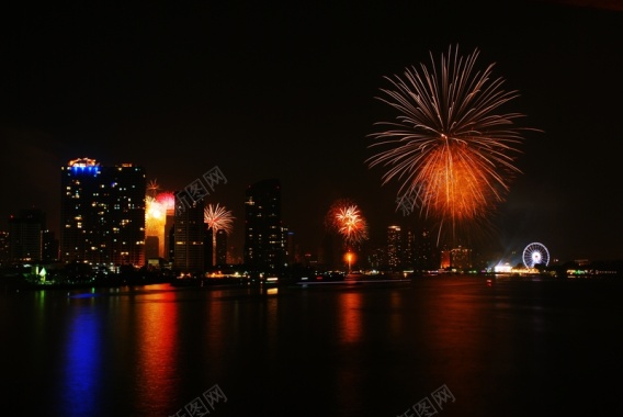 江边美丽的烟花绽放的夜景背景