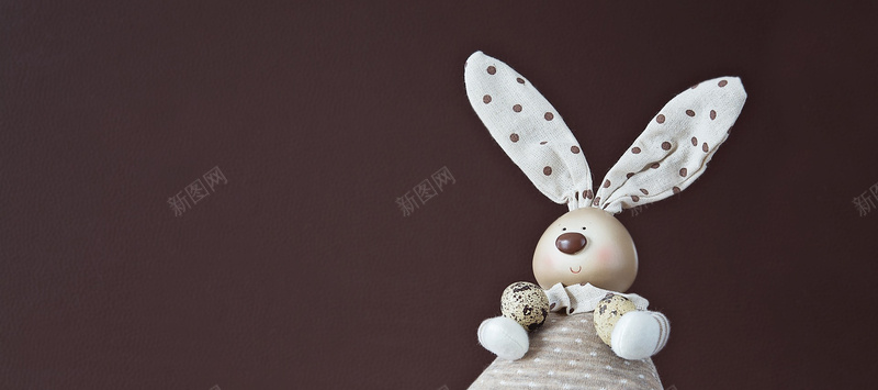 好看的玩具兔子摄影靠在咖啡色墙上的可爱兔子背景