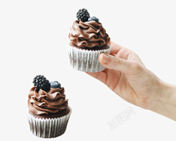 蓝莓巧克力蛋糕手拿着巧克力蛋糕上面有蓝莓高清图片