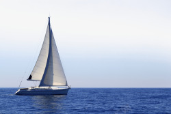 一望无际背景一辆航行在蓝色大海上的帆船高清图片
