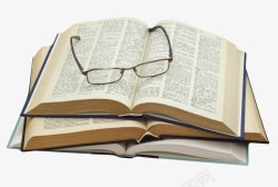 眼镜厚实翻开放着眼镜堆起来的书实物高清图片