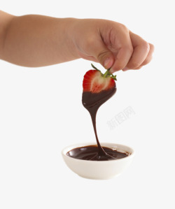 小朋友手拿裹着巧克力酱的草莓素材