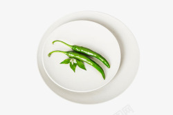 辣椒叶子白色餐盘上的青辣椒高清图片