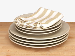 条纹布桌子上一叠干净的餐盘高清图片